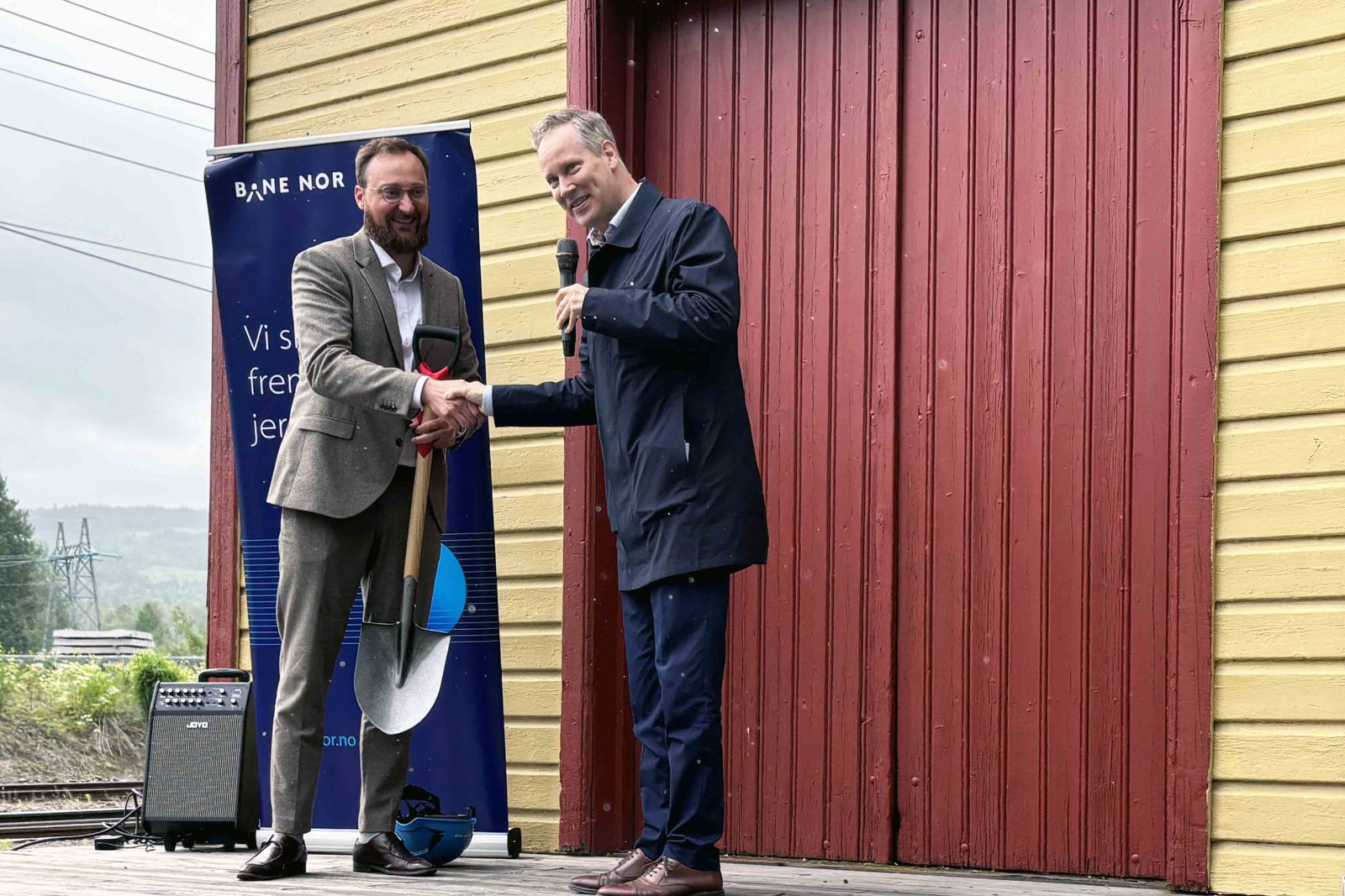 Menn i dress smiler og håndhilser.