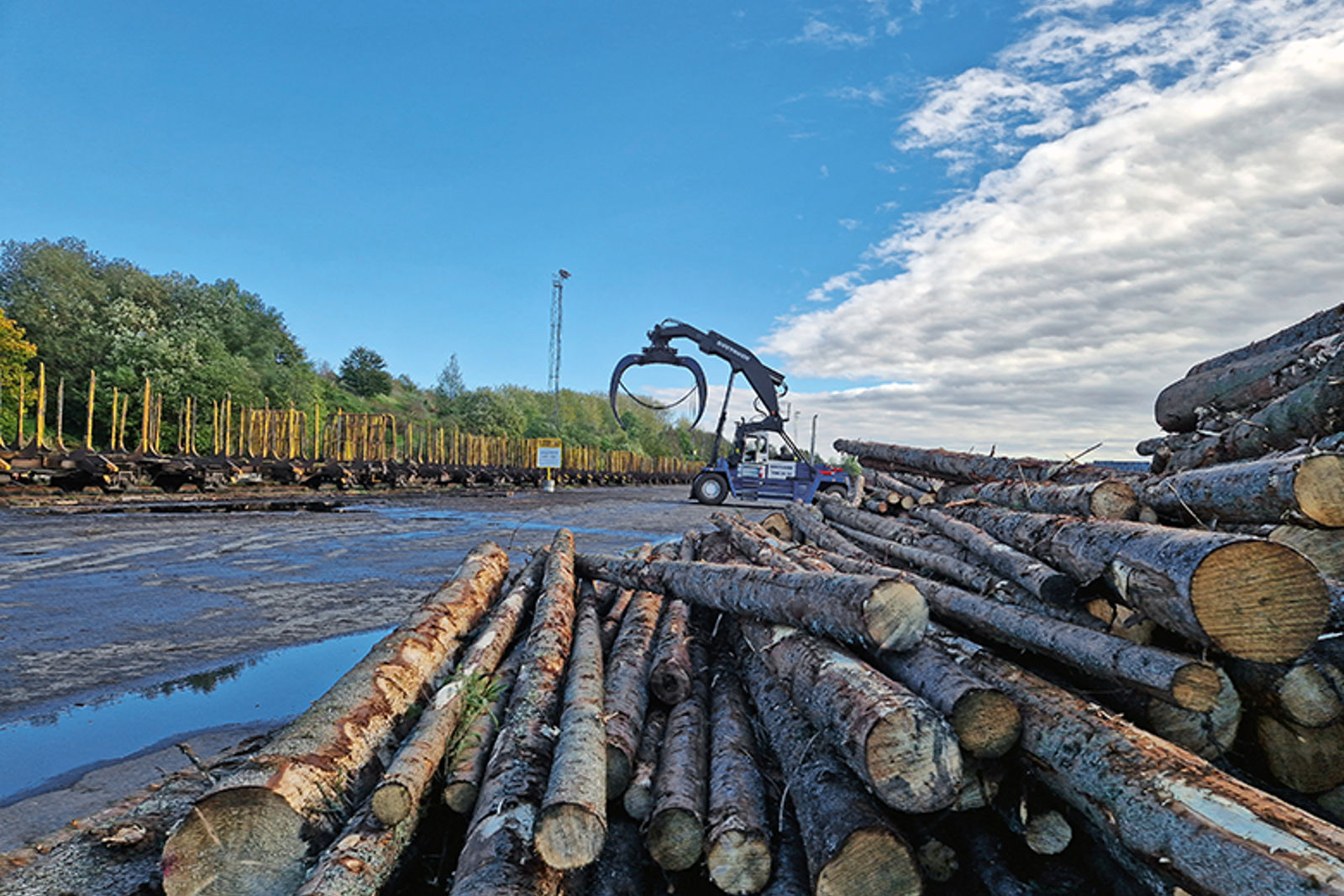 Tømmerstokker, en truck som kan løfte tømmer og godsvogner til transport på jernbanen.