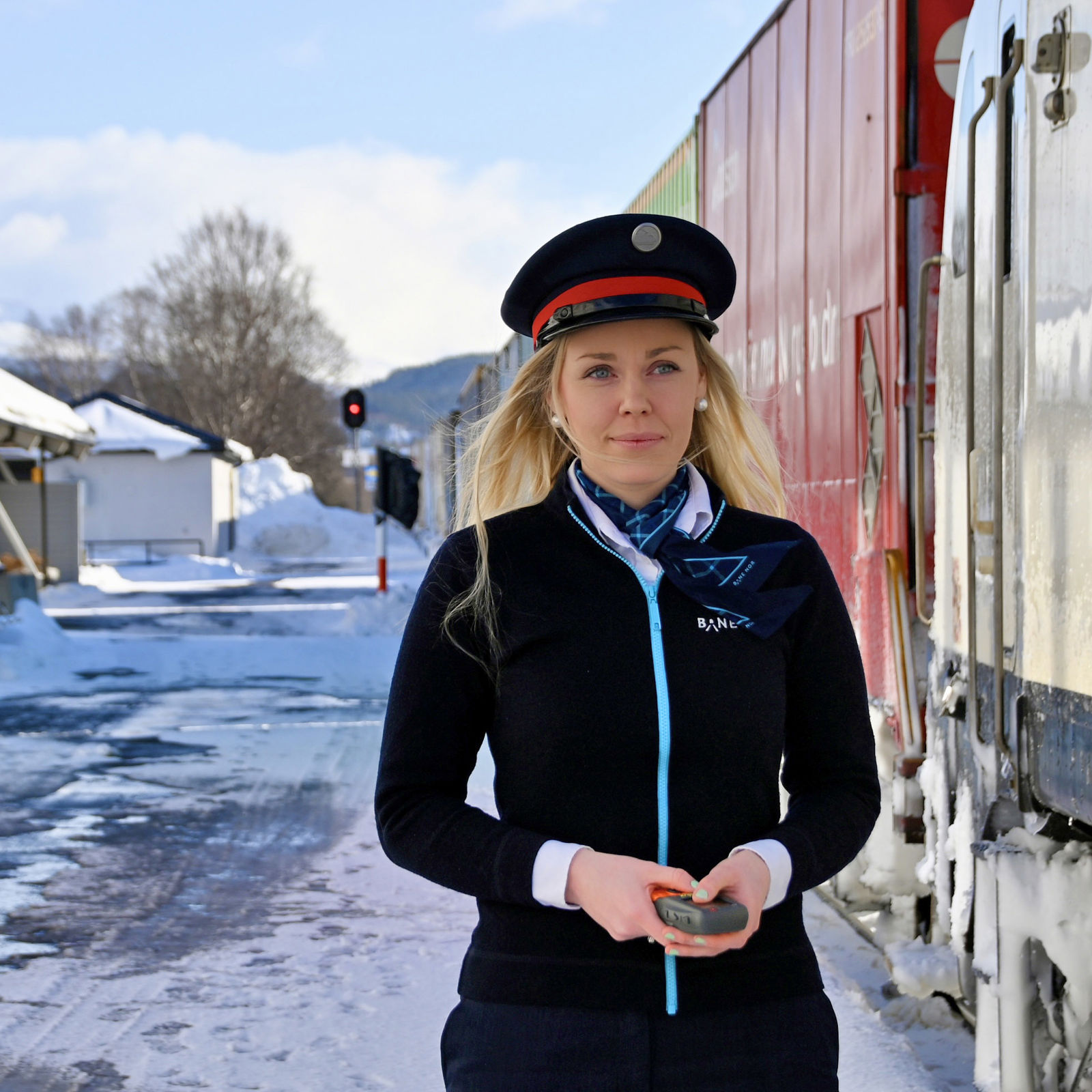 Bilde av ei kvinne i trafikkstyraruniform ved eit tog.