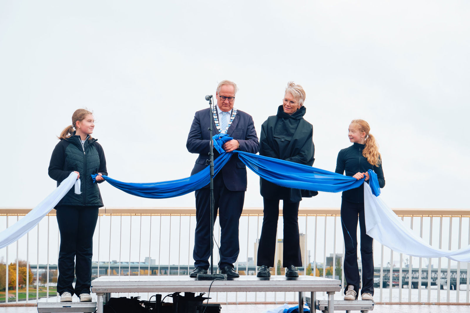 Ordføreren knytter bånd sammen for å symbolsk markere at de to sidene av elven igjen er forbundet.