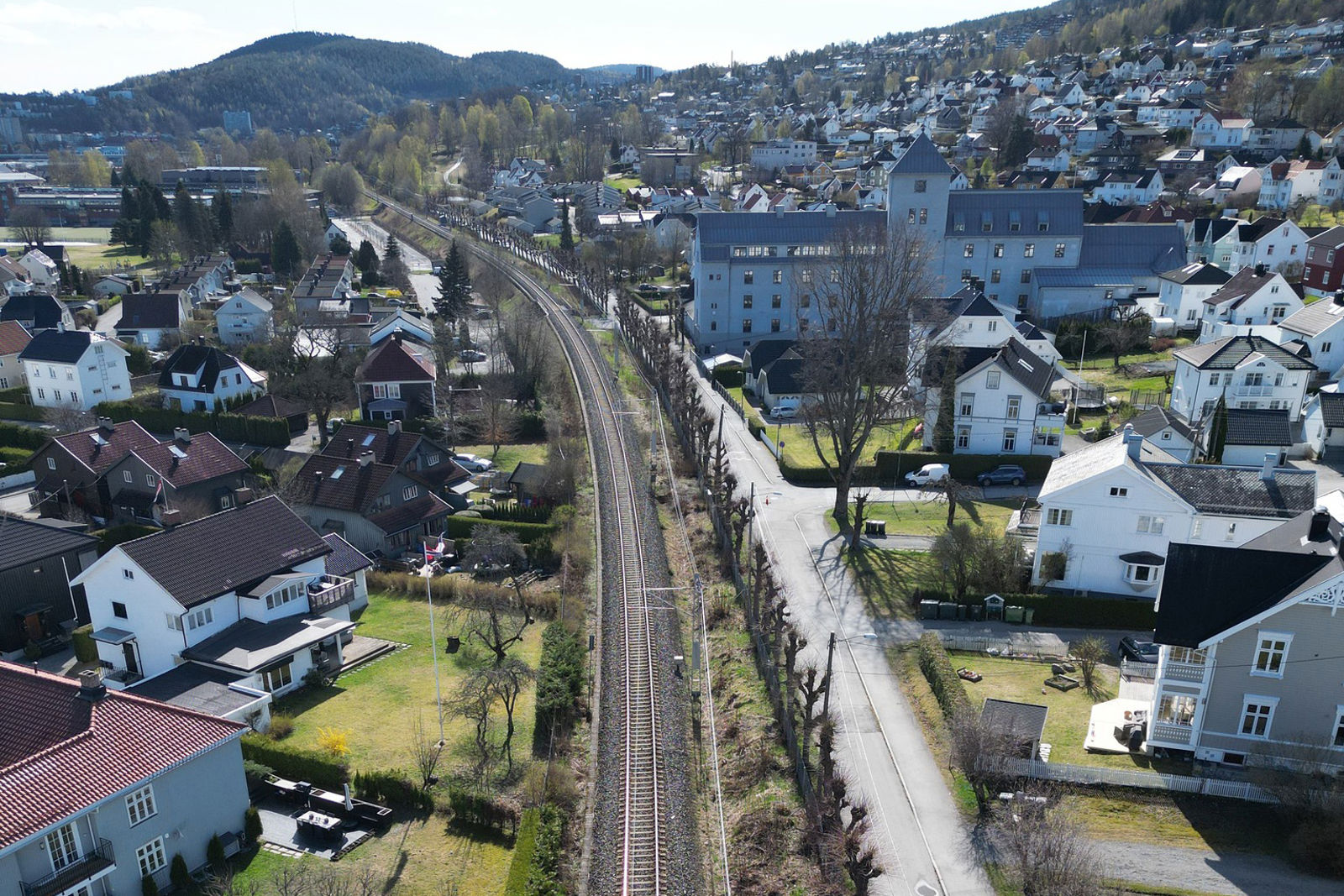 Dronefoto av banen, bebyggelse og villahager.