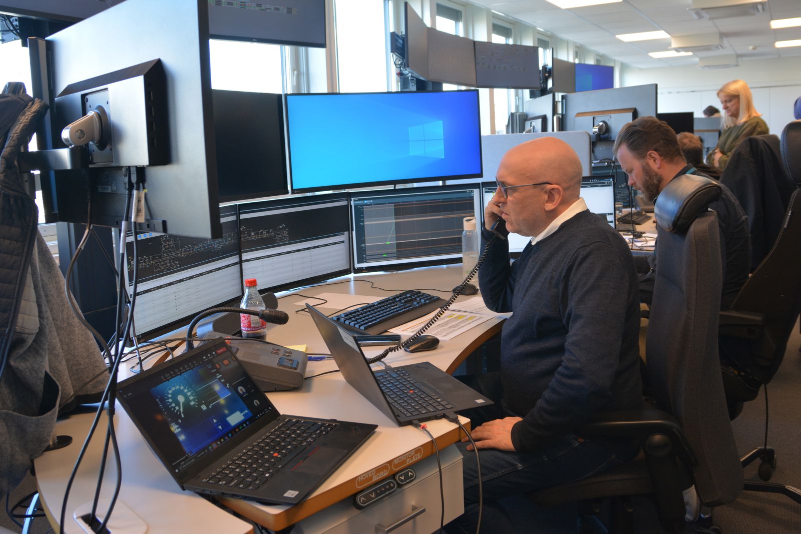 Togleder på Campus Nyland foran testskjermer, i telefon med lokfører.